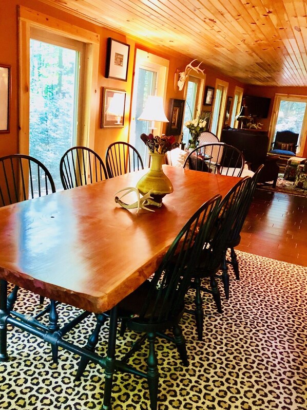 Comedor con mesa de madera, sillas y alfombra de estampado de leopardo.