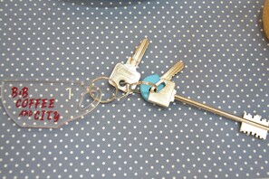 A set of keys with a keychain and a key tag on a polka dot fabric background.