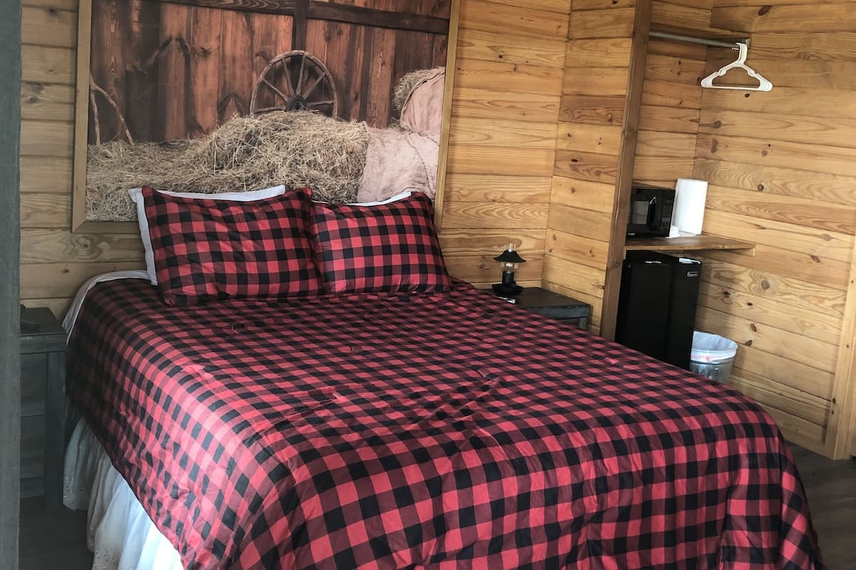 Ein Schlafzimmer einer Holzhütte mit einem Bett, einem Wandheizkörper und einer rustikalen Einrichtung.
