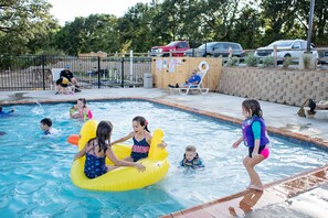 A swimming pool with inflatable floats and people in the water. - The Silver Spur Resort - Campsite (Canton)