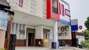 A two-story building with a modern facade, featuring a mix of red and white colors. - Semata Wayang Syariah Homestay (Banjarbaru)