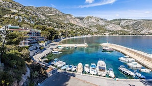 A coastal marina with boats docked, surrounded by rocky hills and residential buildings. - Apartment Eze Seaside in 1st line facing the sea (Èze)