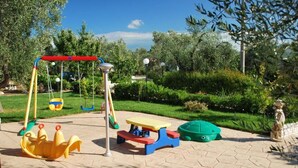 A playground with swings, a slide, and a picnic table. - Apartment "semi-detached Villa" for 5/6 person on the ground floor with separate entrances and with square meters 150 private Garden with Barbecue and Sunbeds (Vieste)