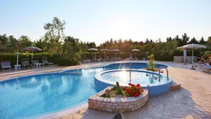 A swimming pool with lounge chairs and umbrellas, surrounded by greenery. - Apartment "semi-detached Villa" for 5/6 person on the ground floor with separate entrances and with square meters 150 private Garden with Barbecue and Sunbeds (Vieste)