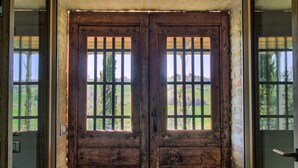 A wooden double door with vertical bars, set in a brick wall with windows. - Fully private fenced villa with pool – ideal for families, pet friendly (Ostra)