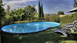 A swimming pool with lounge chairs and a clear sky. - Fully private fenced villa with pool – ideal for families, pet friendly (Ostra)