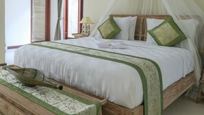 Una cama bien hecha con dosel, una mesita de noche con lámpara y un felpudo decorativo.