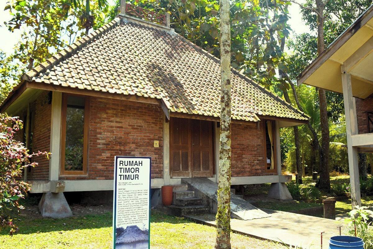 A traditional brick building with a tiled roof and a signboard in front.