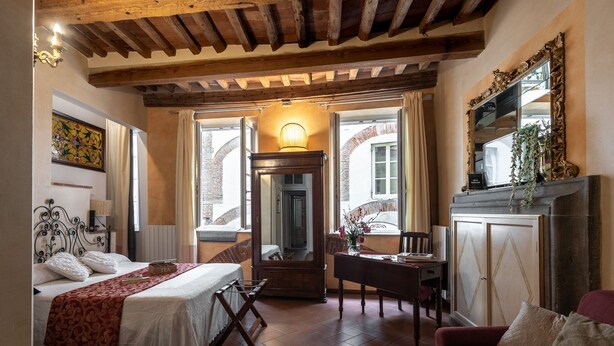 Ein gemütliches Schlafzimmer mit einem Bett, einem Schreibtisch, einem Stuhl und einem Kamin.