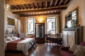 Una camera da letto accogliente con un letto, una scrivania, una sedia e un camino.