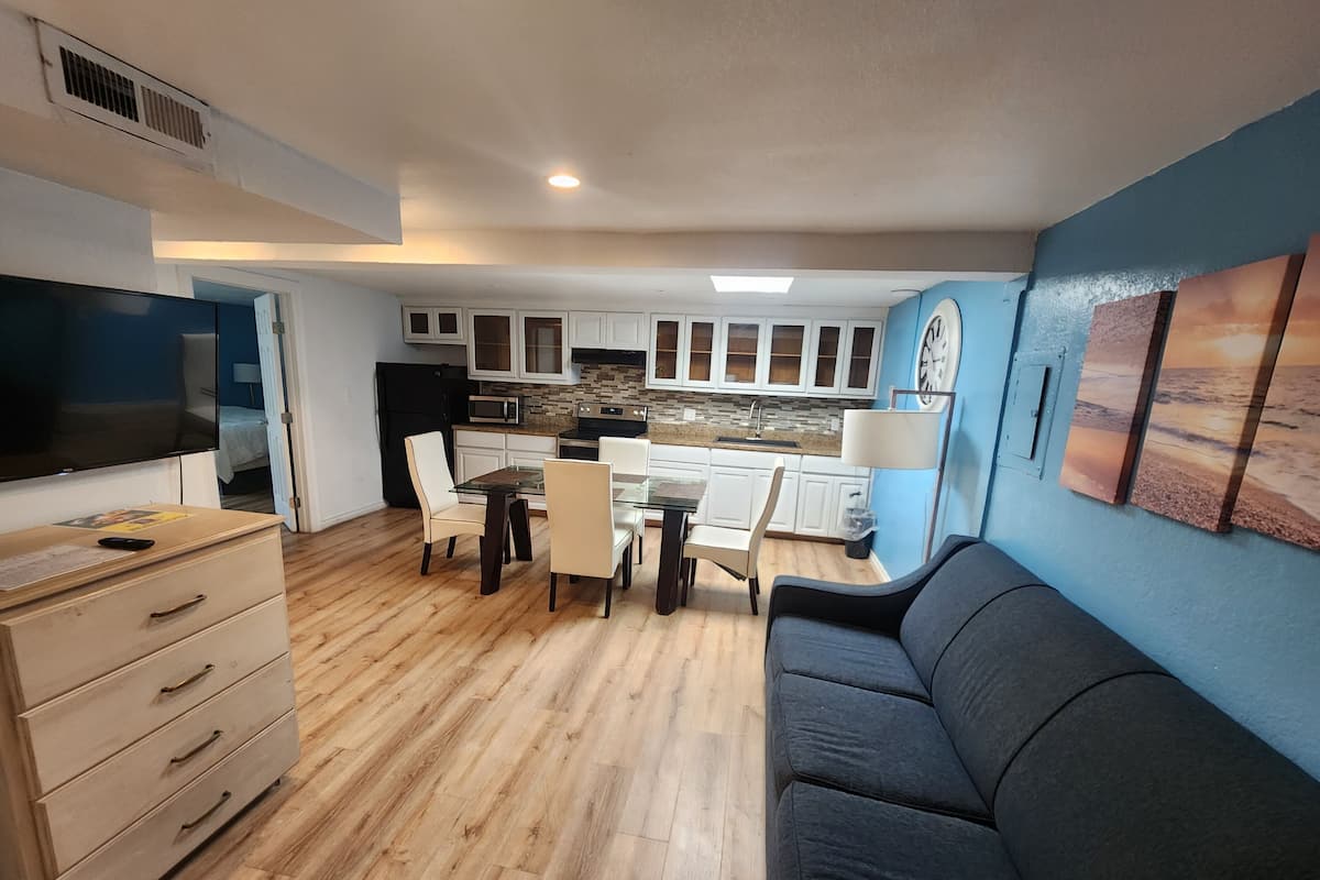 A compact living space with a kitchenette, dining area, and a sofa.