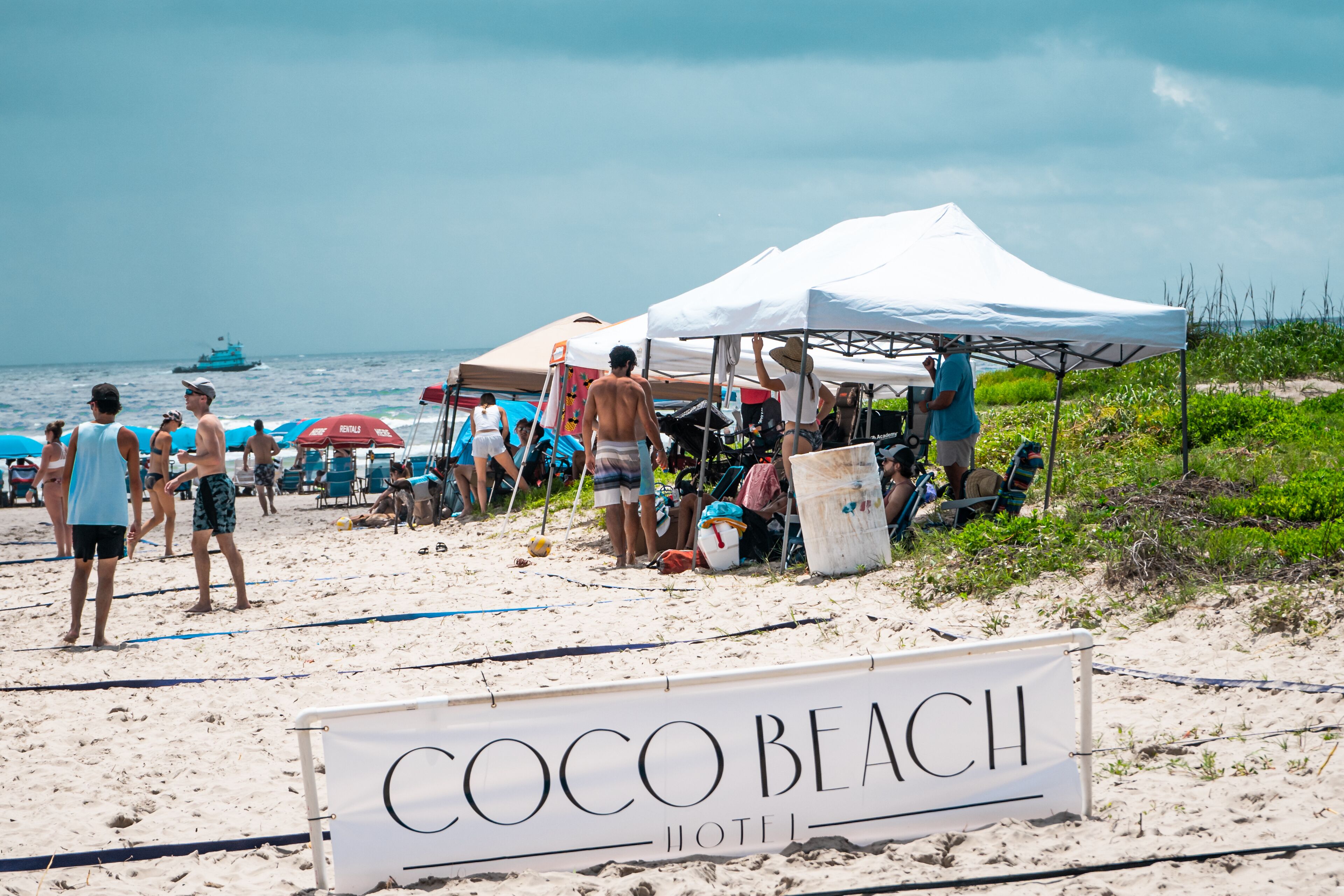 Une scène de plage avec une pancarte indiquant : « Hôtel Coco Beach ».