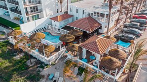 A resort with a pool area, outdoor seating, and a parking lot. - Coco Beach Hotel on South Padre Island (South Padre Island)