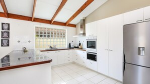 A modern kitchen with white cabinets, stainless steel appliances, and a wooden ceiling. - Michael Street 39, Golden Beach (GOLDEN BEACH)
