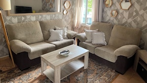A living room with two sofas, a coffee table, and a TV. - Marbella apartment with swimming pool (Marbella)