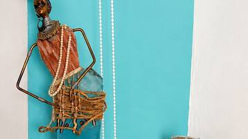 A decorative sculpture with a woven base, a woven basket, and a white wall with teal and white panels.