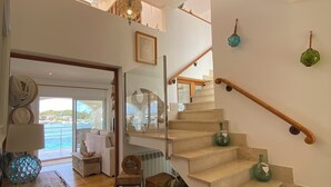 A spacious living area with a staircase leading to an upper floor. - House / Villa - Portocolom (Portocolom)