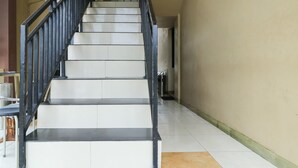 A staircase with black railings and white steps leading to a landing.