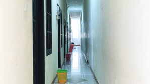 A long, narrow hallway with a tiled floor and a bright light source at the end.