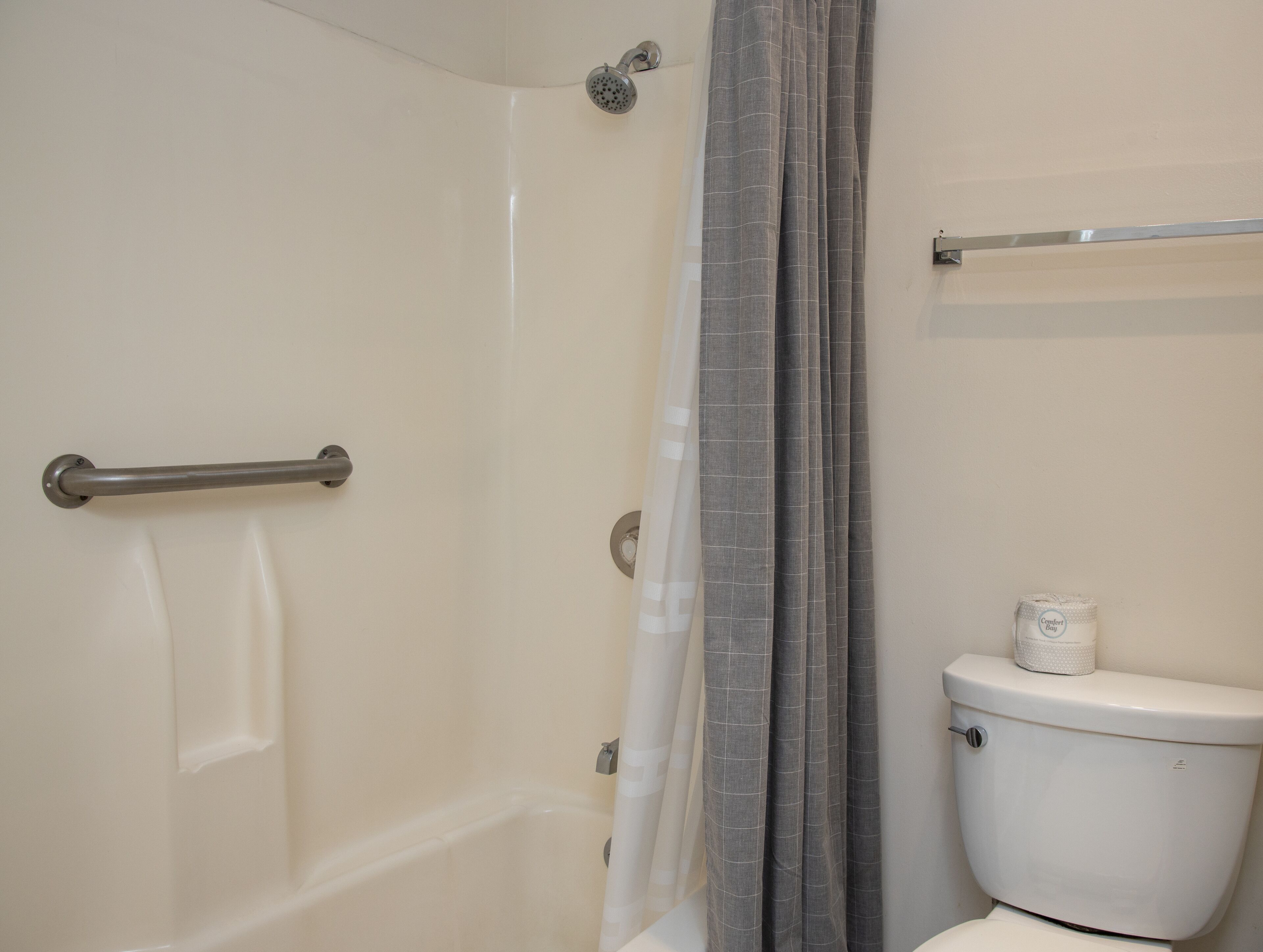 A bathroom with a shower, toilet, and towel rack.
