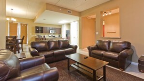 A living room with leather sofas, a coffee table, and a ceiling fan. - Las Marinas #408 | Waterfront Condo • Boat Slip • 6 Minute Walk to Beach (South Padre Island)