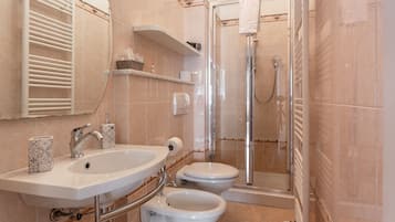 A bathroom with a sink, toilet, and shower.