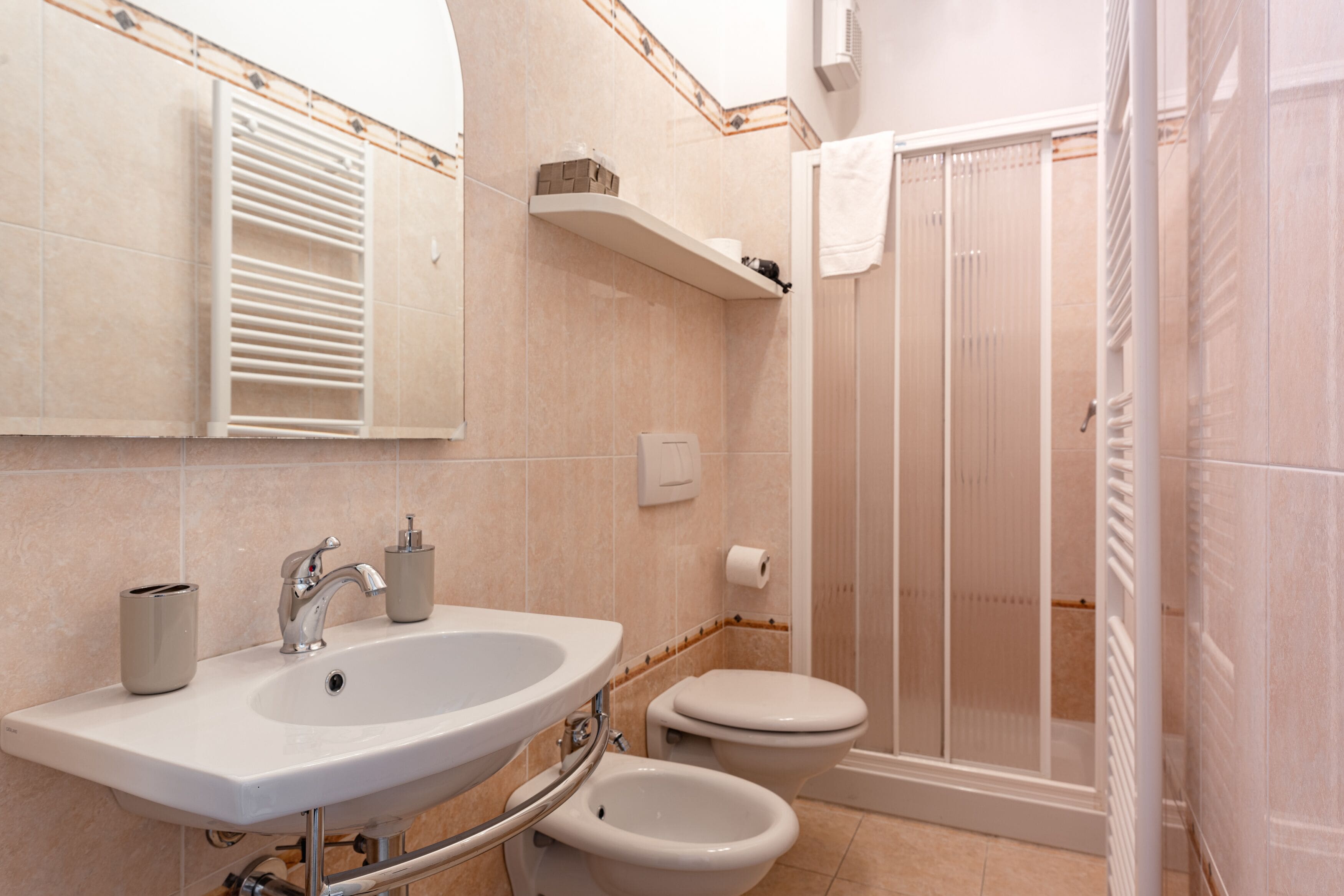 Une salle de bain équipée d’un lavabo, de toilettes, d’un bidet et d’une douche.