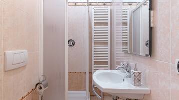 Ein Badezimmer mit Dusche, Toilette, Waschbecken und Handtuchhalter.