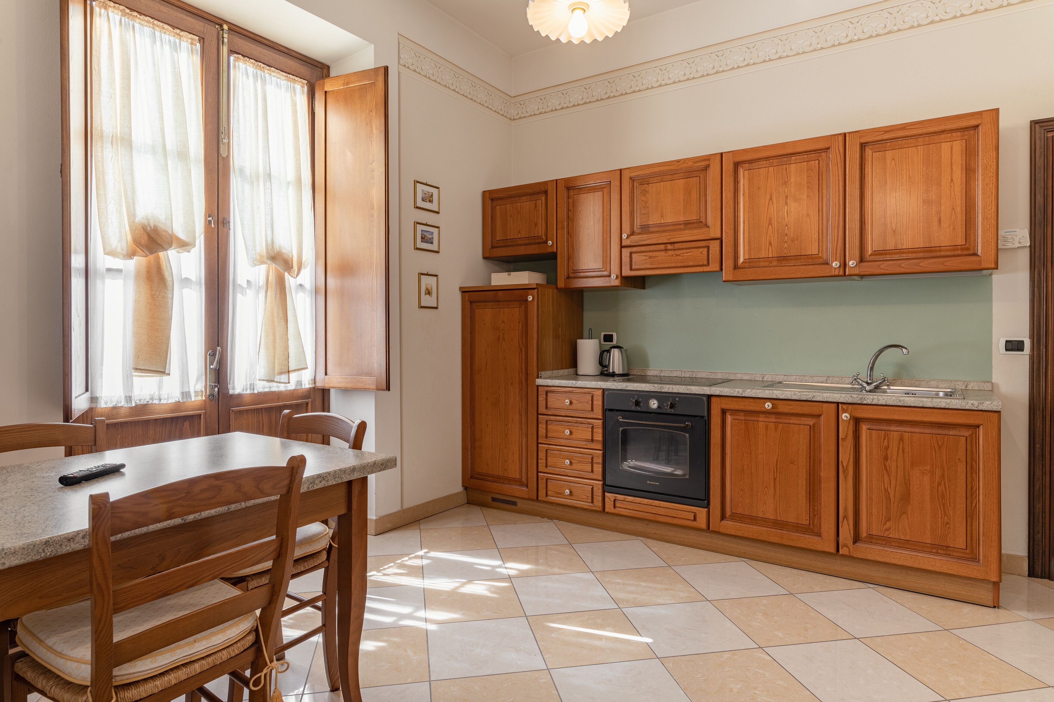 A kitchen with wooden cabinets, a countertop, a stove, and a sink.