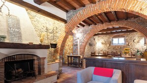 Un interior rústico con chimenea de piedra, vigas de madera y un espacio de estar acogedor.