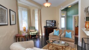 Un salon comprenant un canapé, des fauteuils, une table basse, un téléviseur et une cheminée.