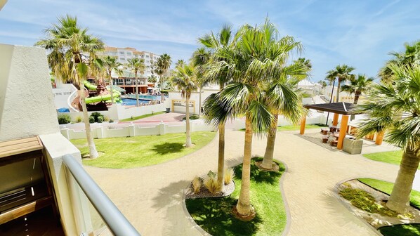 Ein Resort mit Pool, Palmen und einer überdachten Sitzgelegenheit.