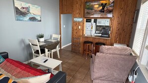 A compact living space with a dining area, kitchenette, and a ceiling fan.