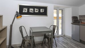 Un coin repas comprenant une table et des chaises, un lampadaire et une œuvre d’art encadrée au-dessus de la table.