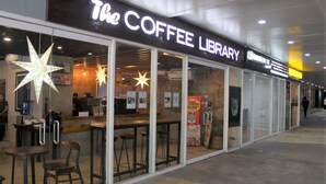 Kaffe Biblioteket med et moderne interiør, glasvægge og stjerndekoration.