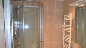Une salle de bain avec une douche à parois de verre, un lavabo et un miroir.