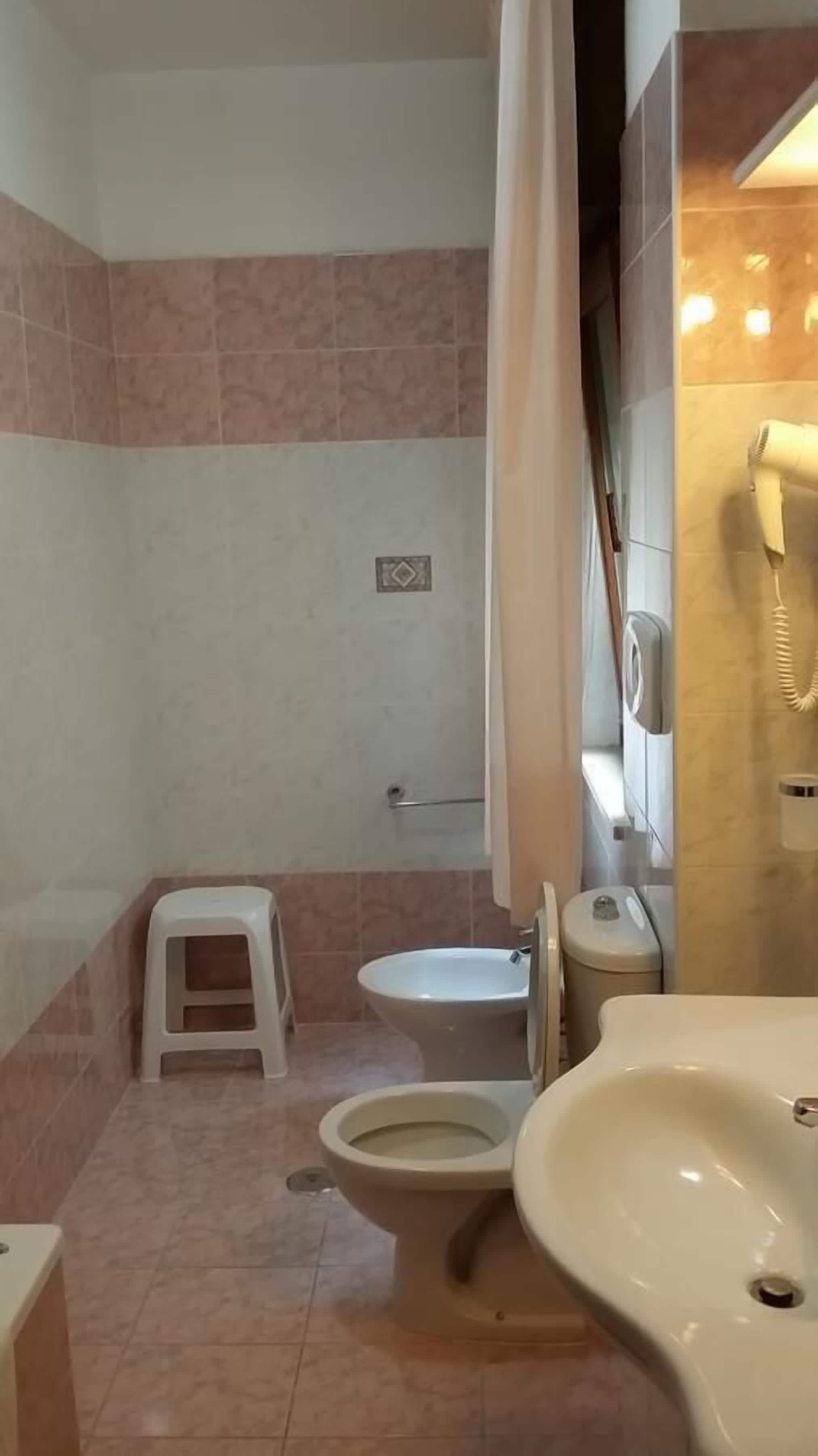 Ein Badezimmer mit Toilette, Bidet und Waschbecken.