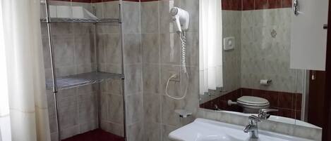 Une salle de bain avec une douche, un lavabo et des toilettes.