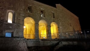 A historic building with three illuminated arches at night. - Il Tulipano (Rogliano)