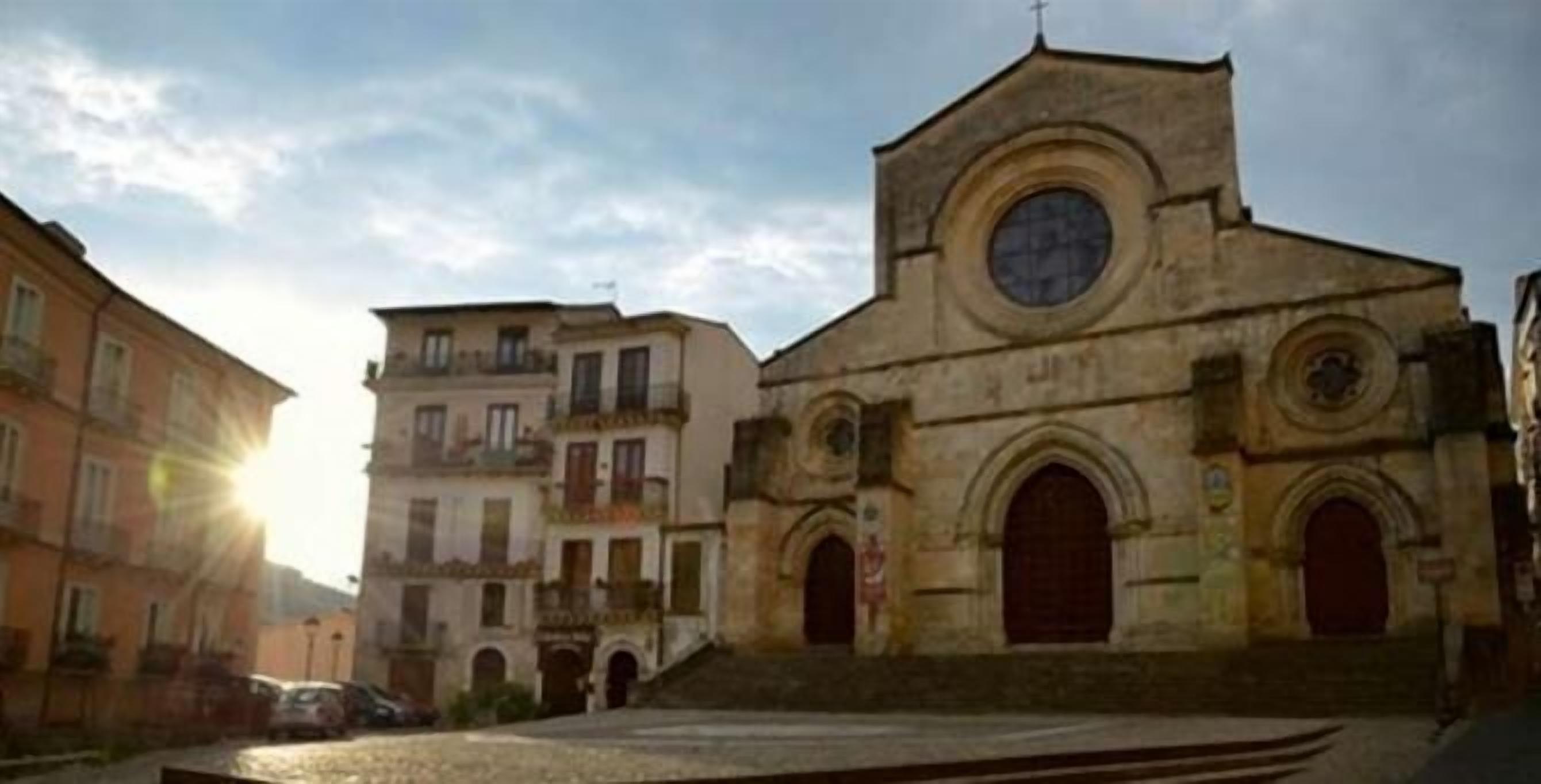 Una chiesa storica con una cupola centrale e finestre ad arco, circondata da edifici tradizionali.