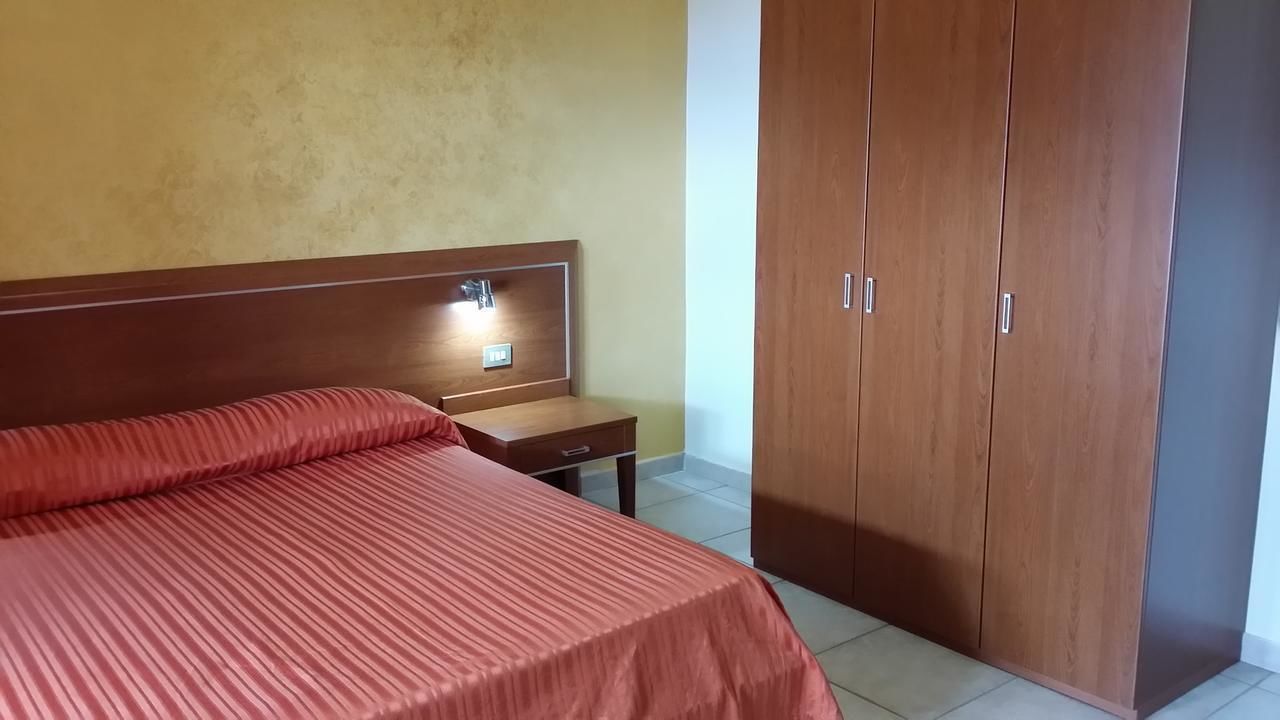 A bedroom with a bed, bedside table, and a wardrobe.