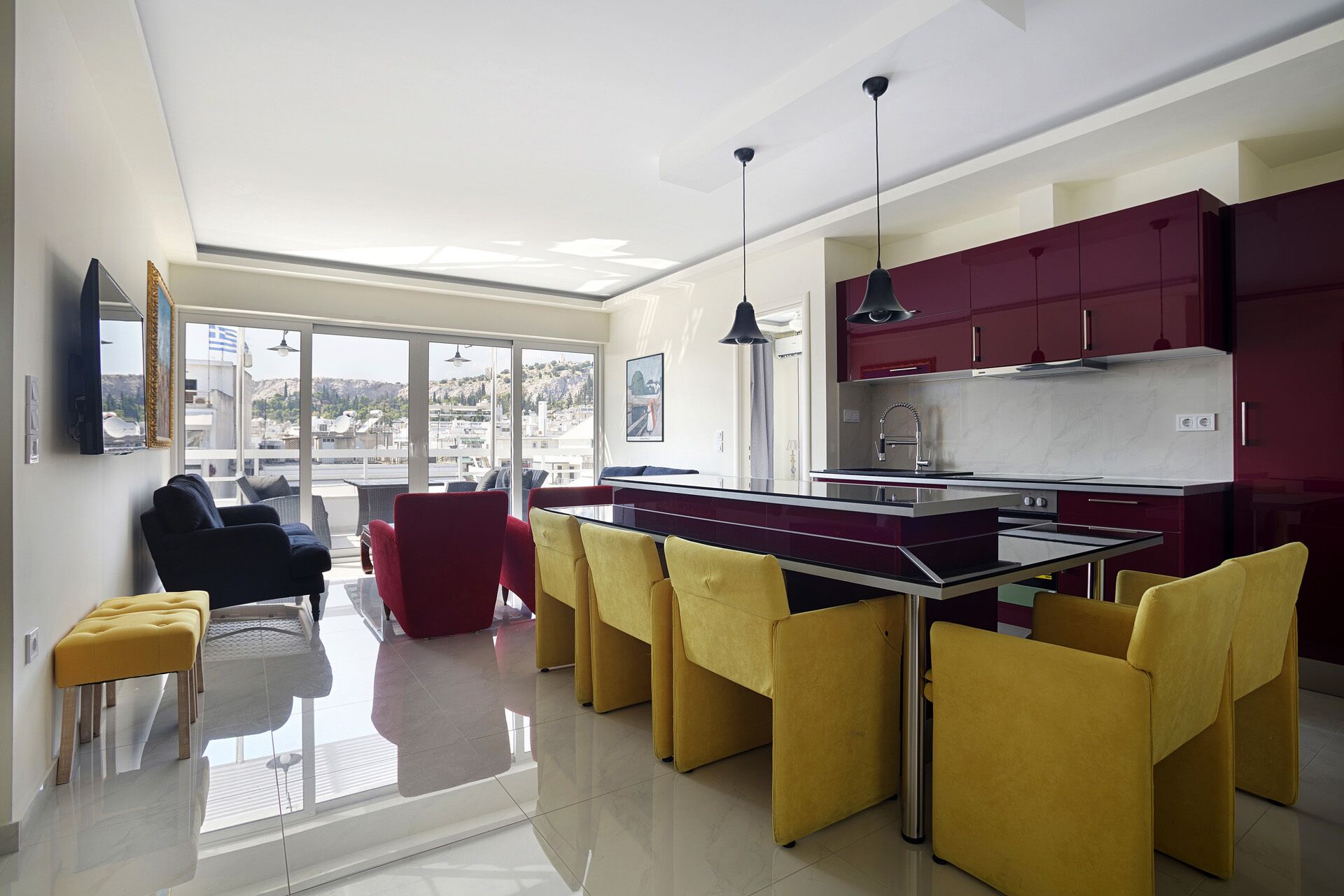 A modern kitchen with a central island, red cabinets, and yellow chairs.