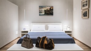 A hotel room with a bed, two bedside tables, a nightstand, a lamp, and a painting on the wall. - Apartment Verona Historical Center 50 meters from the Arena and Piazza Brà - Opera (Verona)