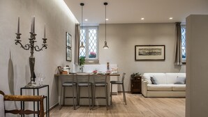 A modern kitchen with a dining area, a white sofa, and a chandelier. - Apartment Verona Historical Center 50 meters from the Arena and Piazza Brà - Opera (Verona)