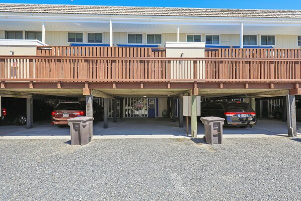 Een gebouw met twee verdiepingen en een overdekte parkeerplaats.