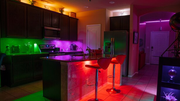 A kitchen with a bar area, a refrigerator, and a door.