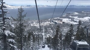 A cable car with a snowy landscape, including a lake and mountains in the background. - Spacious Room at The Marriott Grand Residence (South Lake Tahoe)