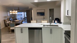 Una cocina moderna con armarios blancos, lavavajillas y una isla grande.