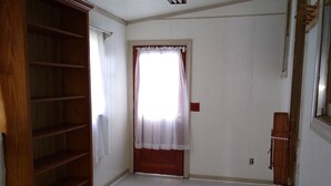 A room with white walls, a wooden bookshelf, a window with sheer curtains, and a ceiling vent. - Charleston "Home-Away-from-Home" - Close to All Major Attractions! (North Charleston)