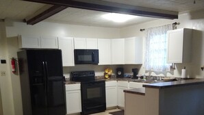 A kitchen with white cabinets, a black refrigerator, a microwave, a stove, and a sink. - Charleston "Home-Away-from-Home" - Close to All Major Attractions! (North Charleston)